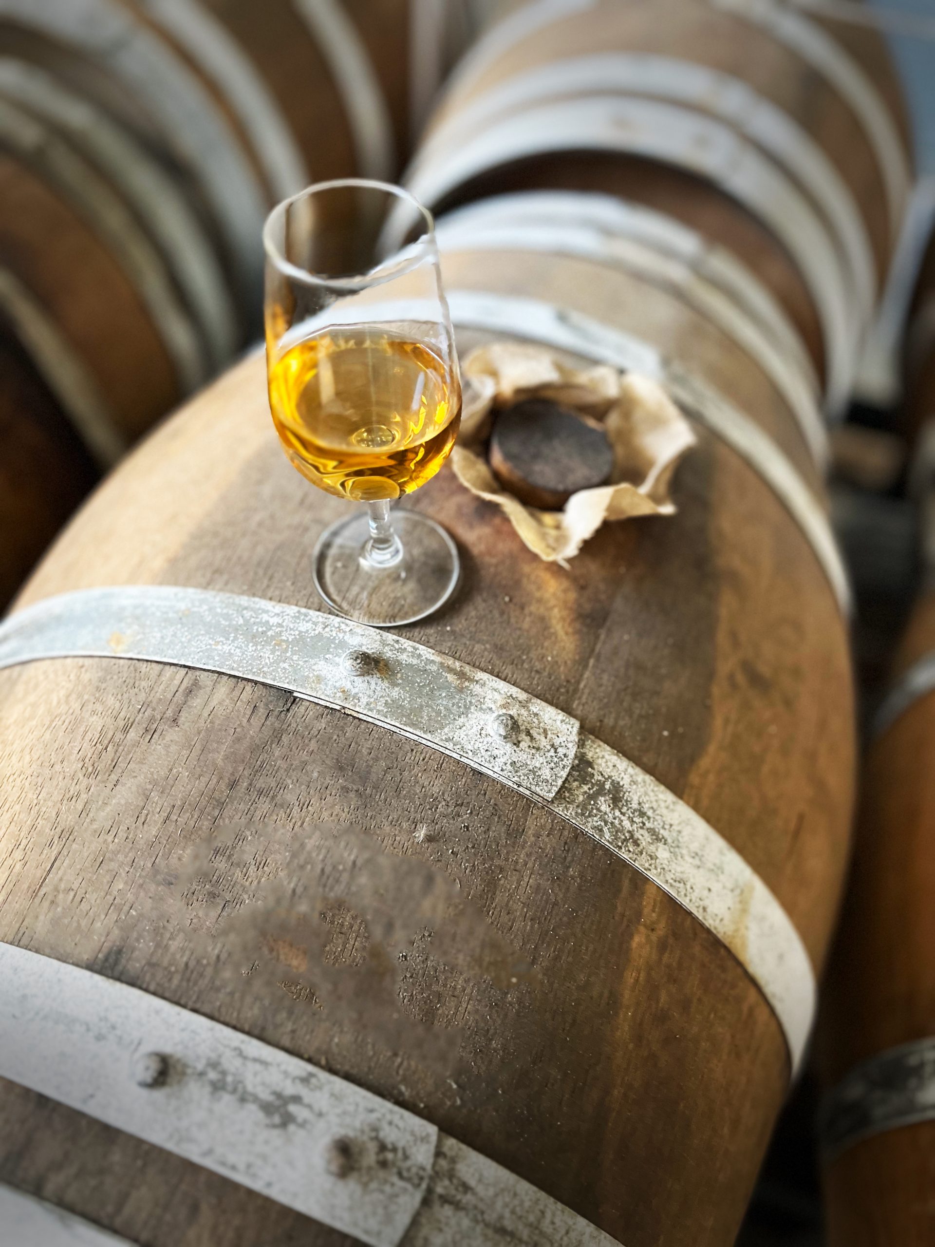 Le vinaigre le vezou dans un verre de dégustation sur un fut de rhum